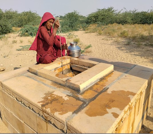 Woman drawing water from a village well in Rajasthan